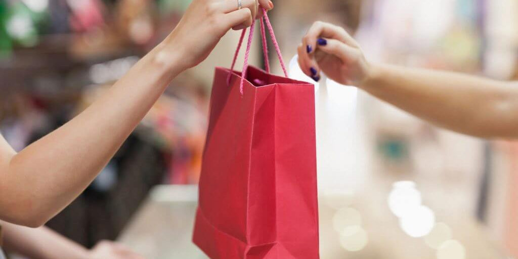 Person giving a red gift bag at an event, showcasing thoughtful gifting and celebration moments.