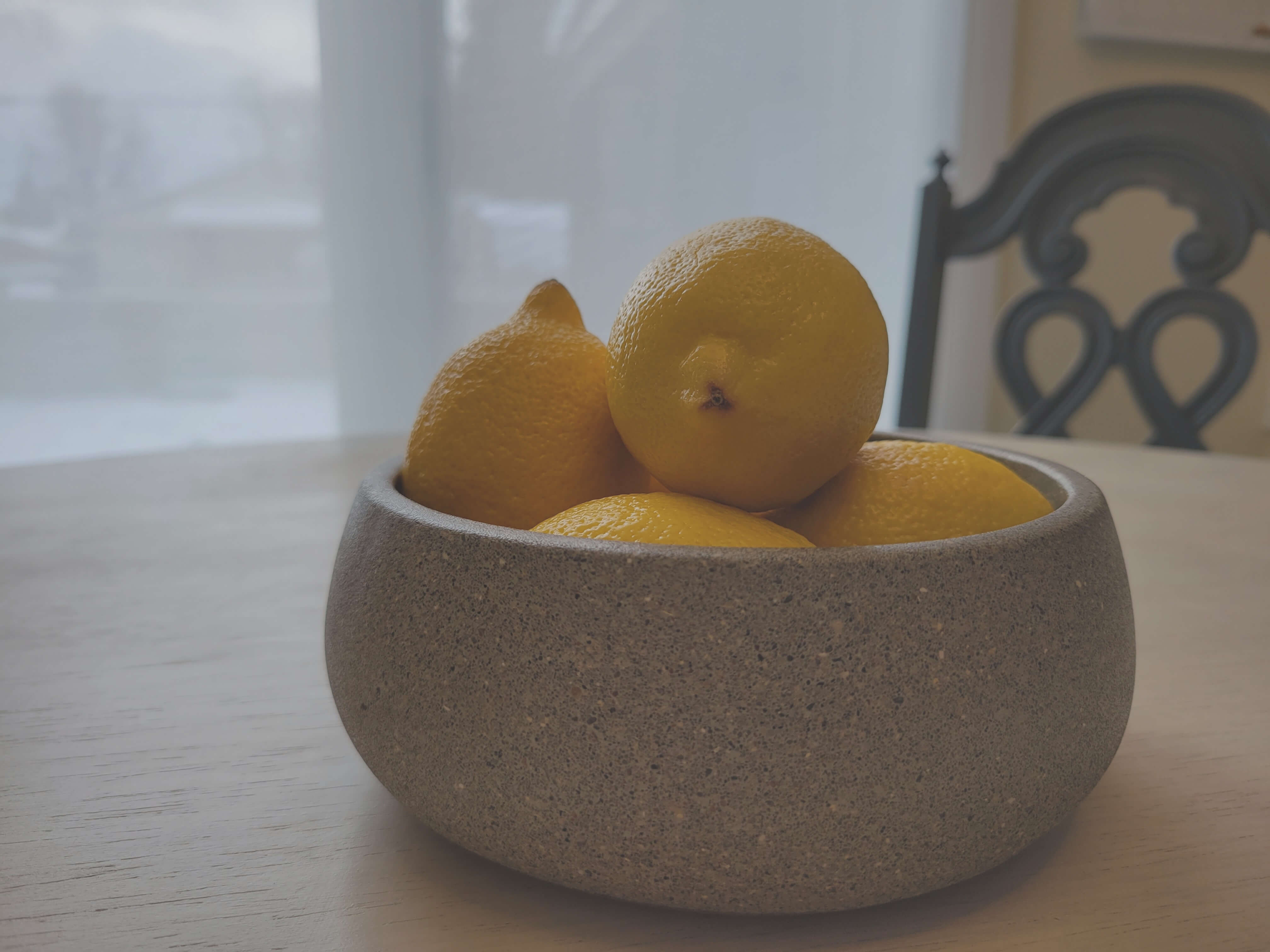 Bright Yellow Lemons in Grey Stone Bowl on Table - Vibrant Kitchen Decor Accessory