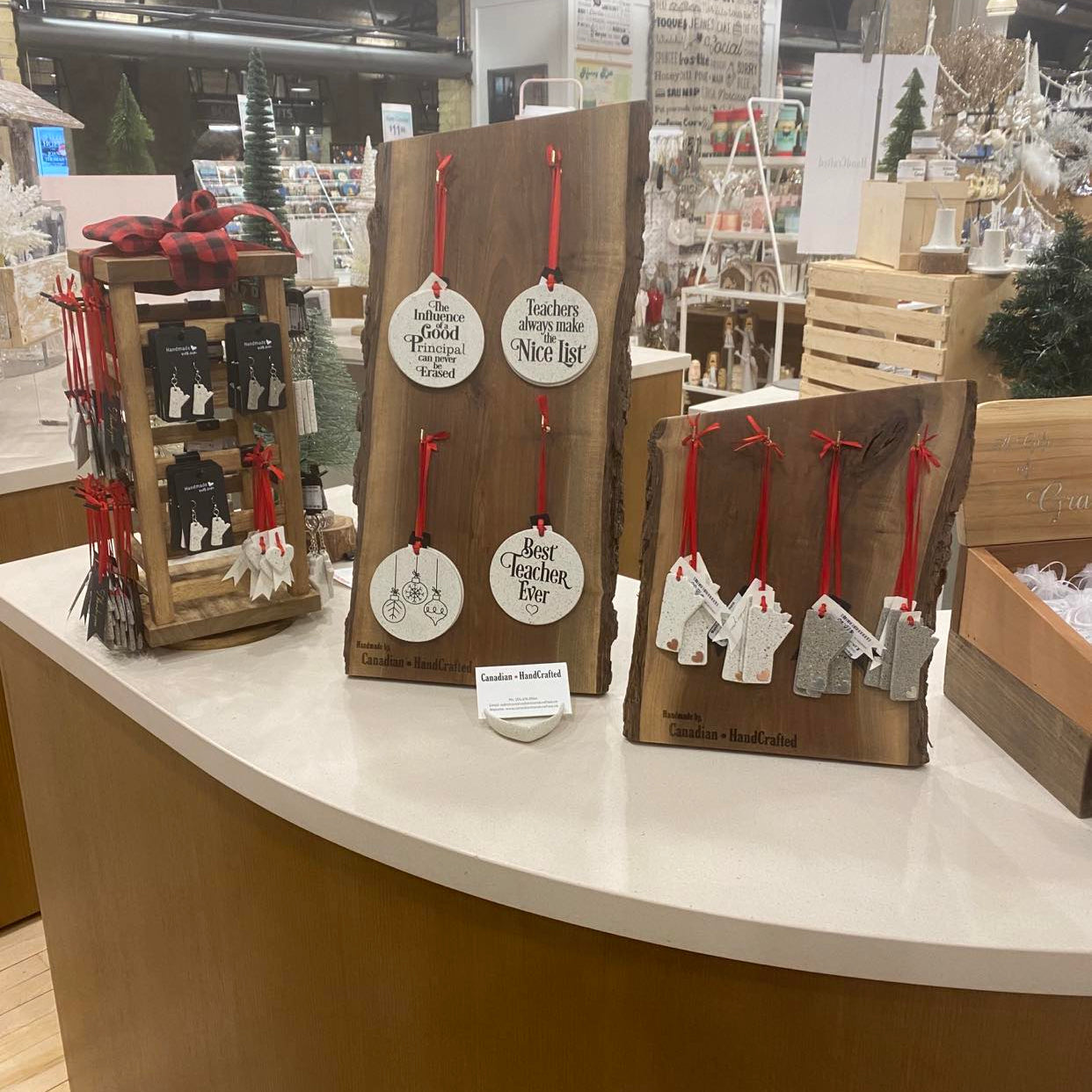 Walnut wood Christmas ornament displays and spinning stand on countertop at Forks Trading Company, Winnipeg, Manitoba, showcasing holiday decor.