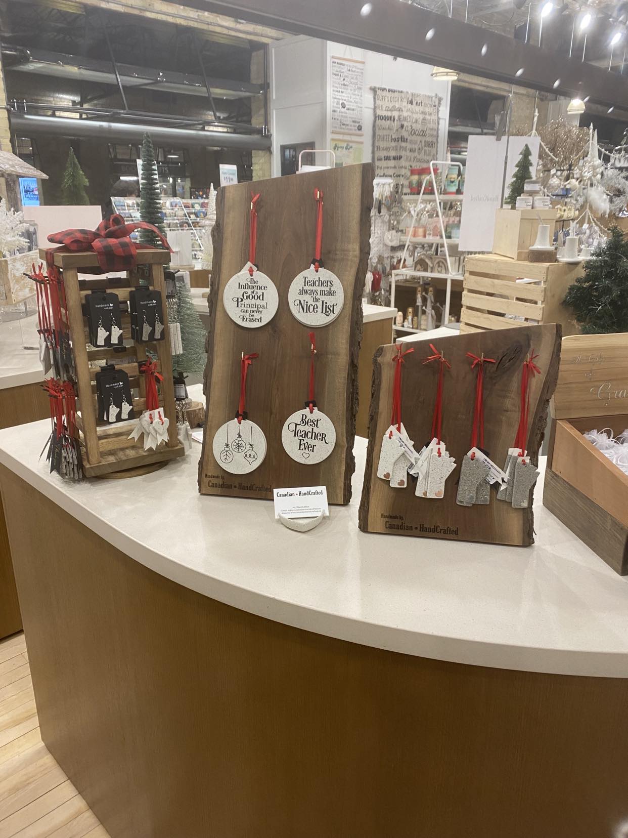 Walnut wood Christmas ornament displays and spinning stand on countertop at Forks Trading Company, Winnipeg, Manitoba, showcasing holiday decor.
