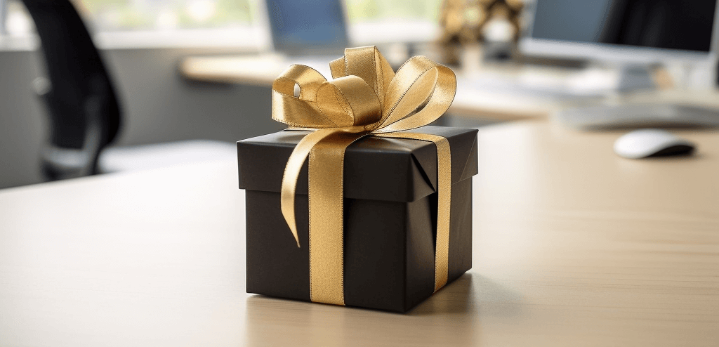 Black and gold wrapped gift on company desk, symbolizing elegant corporate recognition and appreciation.
