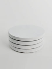 Four chalk white concrete coasters neatly stacked, highlighting their smooth finish and elegant design.
