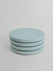 Four pastel turquoise concrete coasters neatly stacked, highlighting their smooth finish and elegant design.