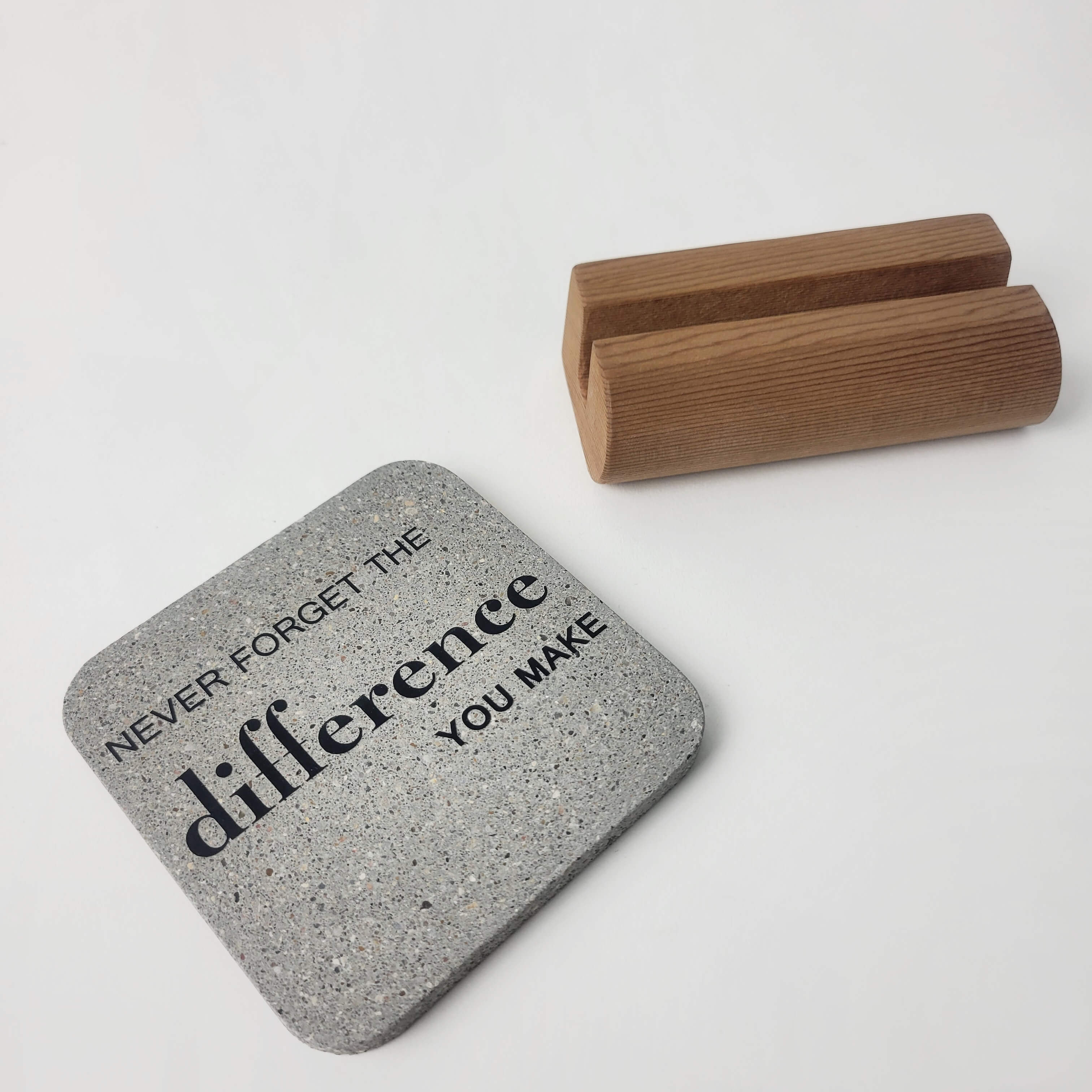 Grey stone motivational mini display 'The difference you make'  lying flat in the foreground with notched upcycled western red-cedar base in the background for office and home decor.
