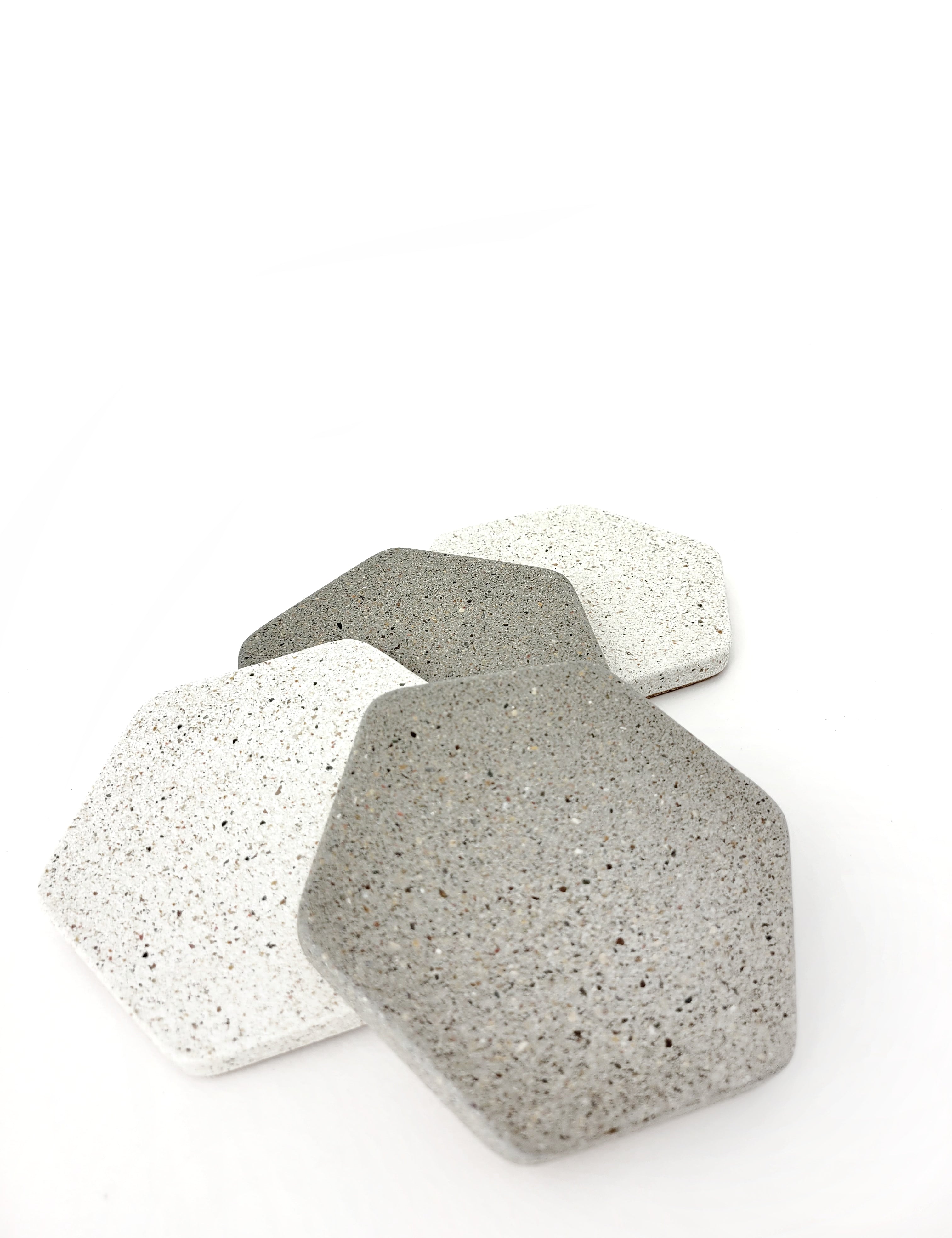 Two grey and two white hexagon sandstone coasters arranged vertically, alternating between grey and white.