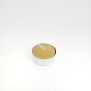 Single natural honey-colored beeswax tealight in a tin cup, perfect for eco-friendly home decor and ambiance.