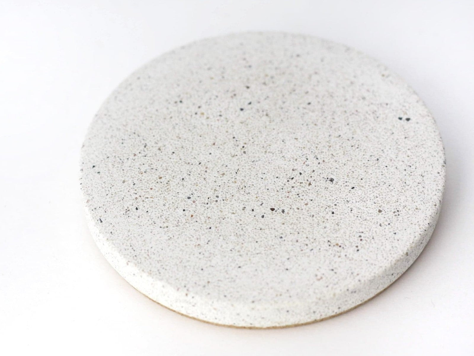 Close-up view of a sparkling white sandstone round coaster, elegant and durable design detail