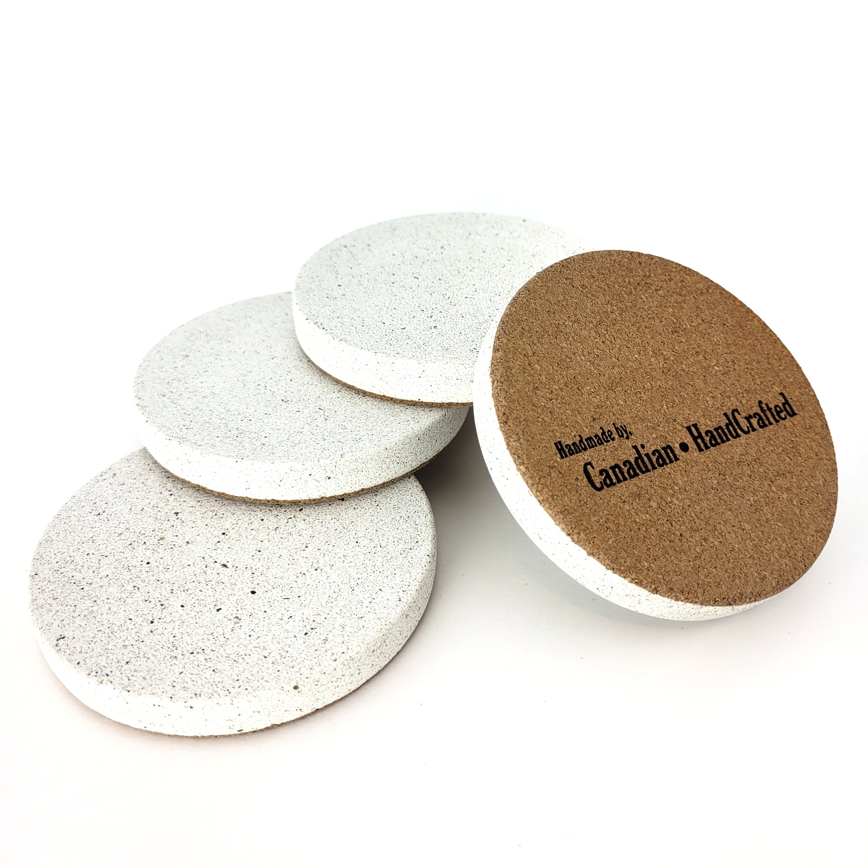 Set of 4 sparkling white sandstone coasters, one showcasing Canadian HandCrafted handmade engraving on the bottom, elegant and durable design